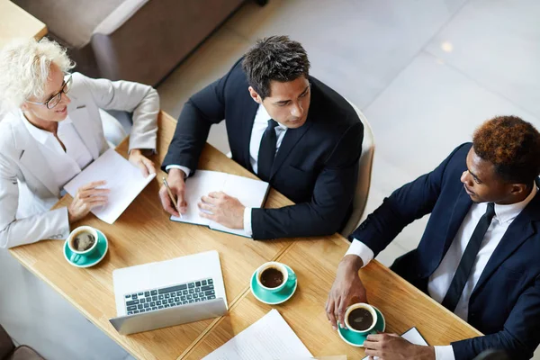 Team Van Zakenmensen Die Samenwerken Aan Tafel Tijdens Een Koffiepauze — Stockfoto