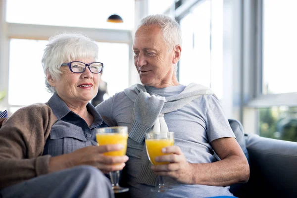 现代高级夫妇在海上度假村的咖啡厅享用早餐时 一边拥抱和拿着新鲜橙汁的眼镜的肖像 — 图库照片