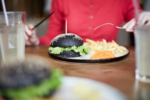 Zeitgenössische Frau Sitzt Tisch Und Isst Cheeseburger Mit Gemüse Café — Stockfoto