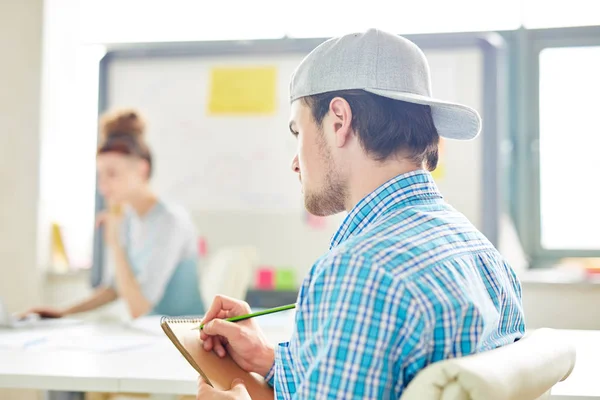 Pensive Young Guy Cap Maken Van Notities Kladblok Aandachtig Luisteren — Stockfoto