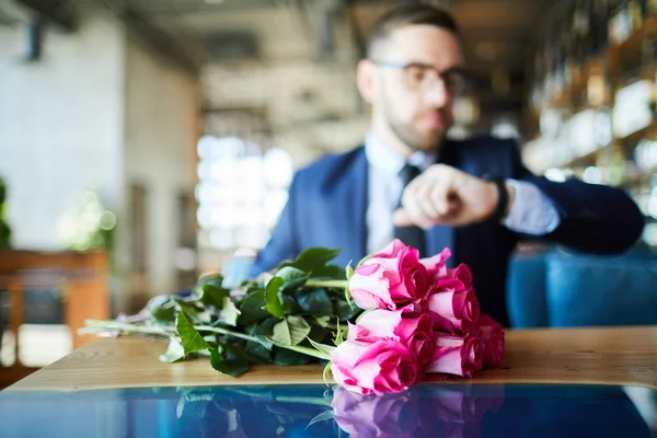 一捆粉红色的玫瑰的背景下 男人等待他的女朋友在桌子上 — 图库照片