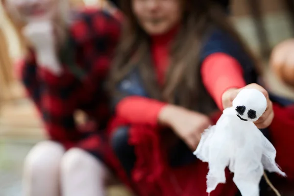 ホワイトおもちゃゴーストとともに黒目によって小さな女の子でハロウィン服装で彼女のお母さんと近くに — ストック写真
