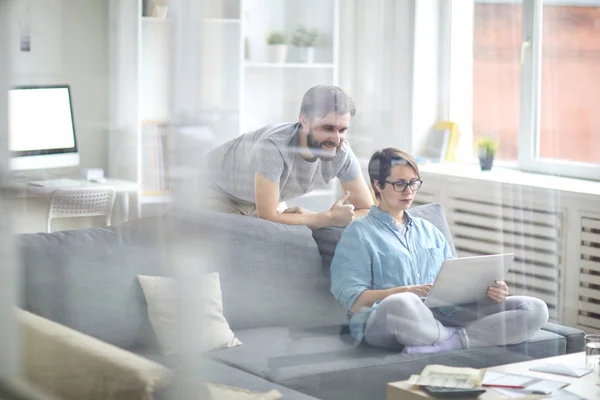 Ung Man Tittar Visning Bärbar Dator Som Innehas Sin Fru — Stockfoto