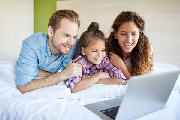 Pareja Joven Adorable Hija Tumbada Cama Frente Computadora Portátil Mientras — Foto de Stock