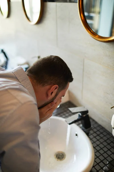 空港の浴室でシンクの上に冷たい水でさわやかな疲れや眠いビジネスマン — ストック写真