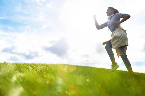 Jonge Sportsvrouw Activewear Joggen Groen Veld Tegen Bewolkte Hemel Ochtend — Stockfoto