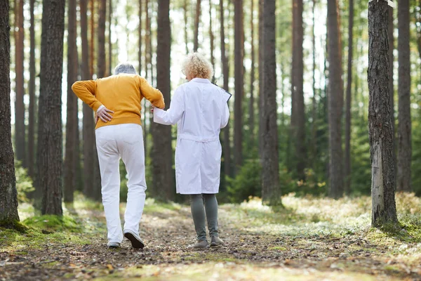 Rückenansicht Des Arztes Hilft Senioren Mit Rückenschmerzen Während Den Waldweg — Stockfoto