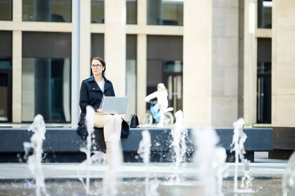 Serious Pensive Female Freelancer Black Coat Sitting Fountain Looking Away — Stock Photo, Image