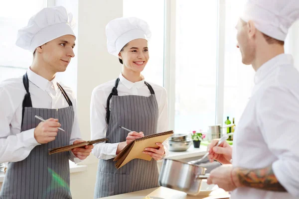 Alegre Optimista Joven Interno Cocina Uniforme Haciendo Notas Clase Cocina —  Fotos de Stock