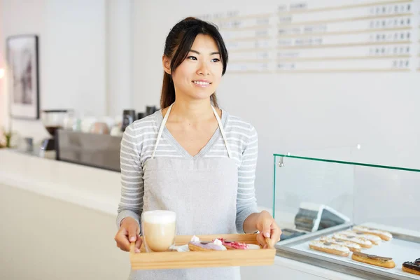 Młoda Azjatycka Kelnerka Odzieży Roboczej Świeżymi Przeszklonymi Eklerkami Szklanką Koktajlu — Zdjęcie stockowe