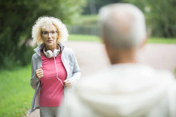 Envejecida Mujer Activa Corriendo Parque Viendo Hombre Moviéndose Hacia Ella — Foto de Stock