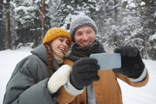 Fröhlich Aufgeregtes Junges Paar Warmer Kleidung Steht Winterwald Und Lächelt — Stockfoto