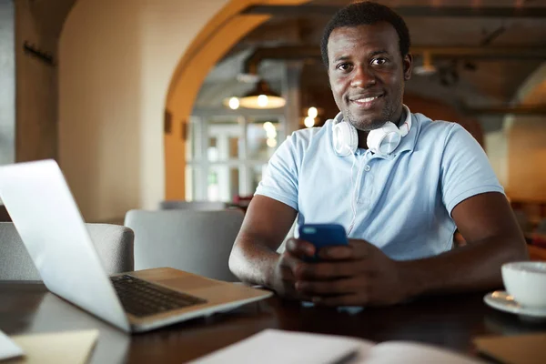 African American Guy Casualwear Texting Smartphone While Sitting Cafe Laptop — Stock Photo, Image