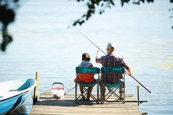 Visão Traseira Homem Seu Filho Sentado Frente Água Pesca Juntos — Fotografia de Stock