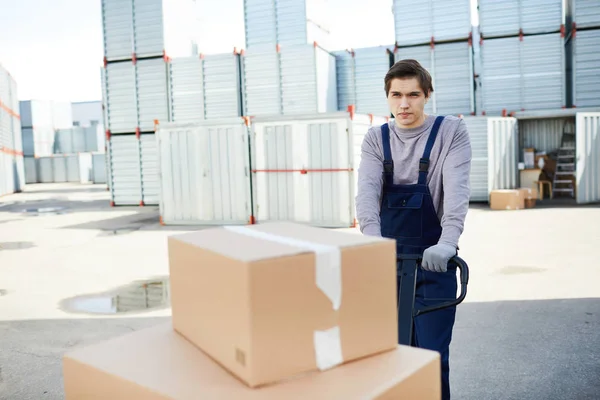 Ung Arbetare Driver Hög Packade Lådor Framför Sig Utomhusarbete — Stockfoto