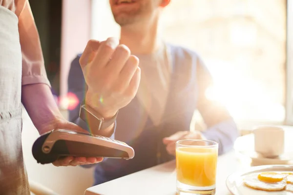 年轻人在咖啡店支付早餐时使用可穿戴支付设备 使用智能手表付款的特写 — 图库照片