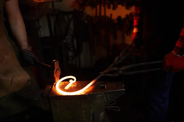 Close Trabalhadores Irreconhecíveis Bigorna Fazendo Forma Torcida Barra Metal Usando — Fotografia de Stock