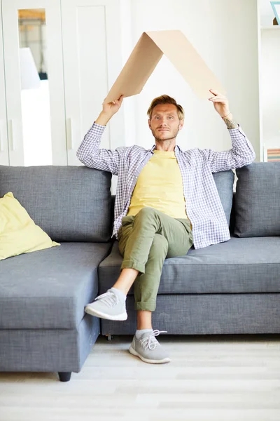 Young Casual Man Holding Carton Roof His Head While Sitting — Stock Photo, Image