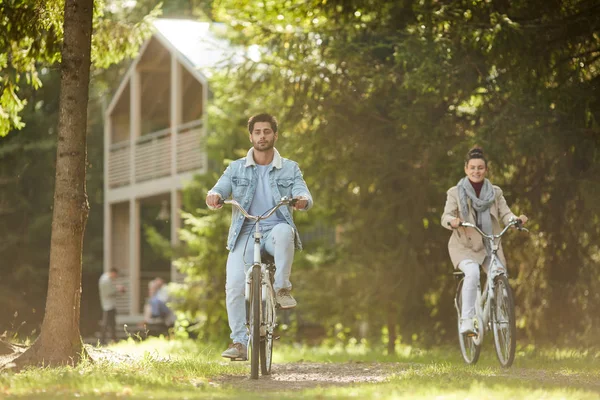 休闲在乡村 积极的年轻夫妇骑自行车的人在温暖的秋天的乐趣和骑自行车在森林 — 图库照片