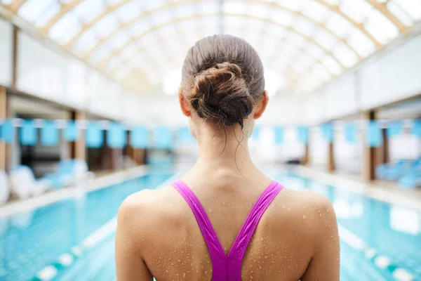 ジャンプの前にプールの前で水着で濡れた女性の背面図 — ストック写真