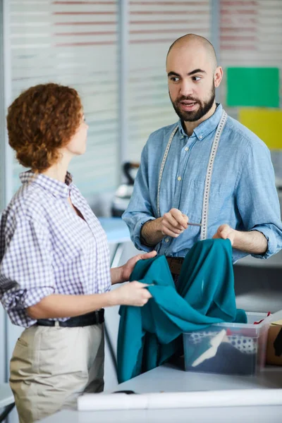 Dos Jóvenes Diseñadores Moda Sosteniendo Una Pieza Tela Consultando Sobre — Foto de Stock