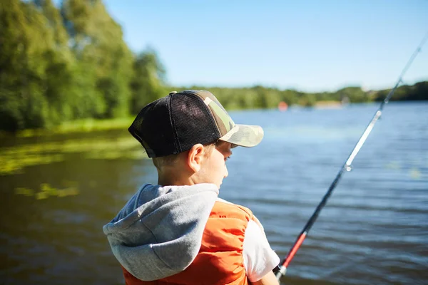 夏天的一个阳光灿烂的周末 一个带着钓竿在河边钓鱼的小男孩 — 图库照片