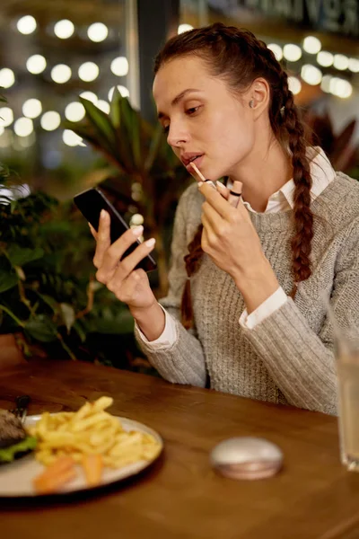 Kafede Akıllı Telefon Ekranına Bakarken Yemekten Sonra Dudak Parlatıcısı Uygulayan — Stok fotoğraf