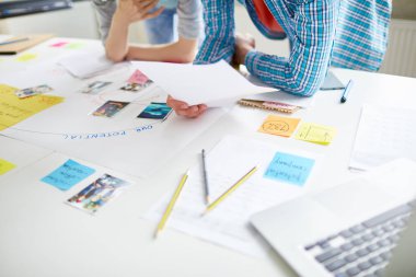 Belgeyi tartışırken ve ev ödevini hazırlarken işyeri üzerine eğilen üniversite grup arkadaşları