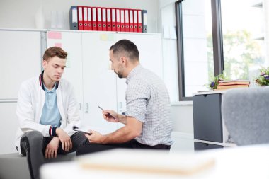 Öğretmen tavsiyelerini dinleyen ve bireysel derste kağıdına yorum yapmayan üzgün öğrenci