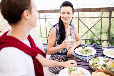 Two young dates having organic food and homemade drinks by lunch on their date in outdoor cafe clipart