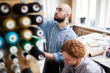 Yeni koleksiyon üzerinde çalışmaları için kumaş ve diğer malzemeleri hazırlayan genç terziler küçük bir grup
