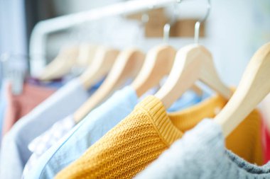 Modern moda ve tasarım stüdyosunda rahat giysiler koleksiyonu ile ahşap askıları Satır