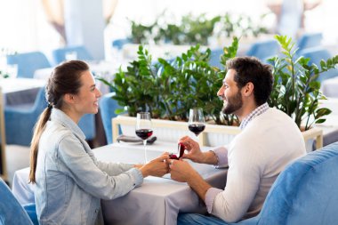 Mutlu genç kadın gülümseme ile onun erkek arkadaşı bakıyor ve romantik bir tarih sırasında onun önerisi için Evet söyleyerek
