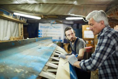Ciddi genç usta çalışma anları hakkında danışmanlık yaparken onun üst düzey meslektaşı bakıyor