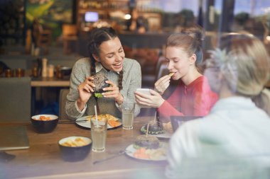 Fast food kafede vakit geçirirken öğle yemeğinde komik selfie yapan sevimli kızlar