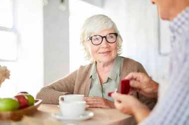 Üst düzey kadın kocası gösteren yüzüğünü yıldönümü için küçük kadife kutusunda bakarak