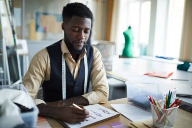 Ciddi genç moda tasarımcısı onun stüdyo veya atölye giysi yeni koleksiyonu oluşturma