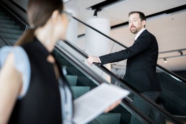 Genç kendine güvenen işadamı astıyla konuşurken toplantı ya da brifing için yukarı çıkıyor.