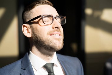 Pencereile güneşli bir gün zevk gözlük ve takım elbise Mutlu adam