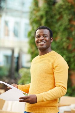 Başarılı ve kendine güvenen genç işadamı dışarıda çalışırken size bakıyor