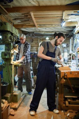 Ahşap iş parçalarını el aletleri ve makine ile işleyen iki ahşap ustası