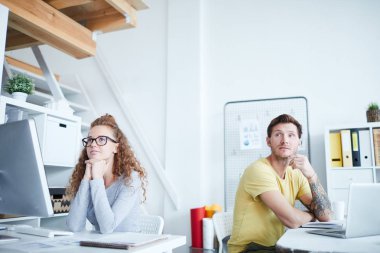 İşyerlerinin yanında oturan ve yayın veya sunum izleyen iki genç ofis yöneticisi