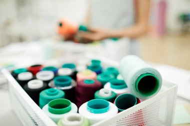 Atölyede masaya renkli iplik makaralı konteynerin yakın çekim yeri