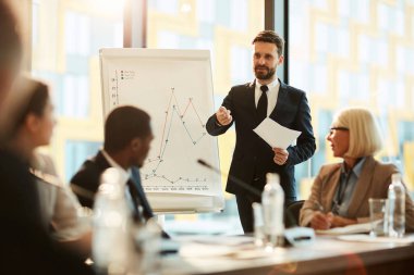 Zarif işadamı veya antrenör seminerde rapor yaparken izleyicilere soru soran