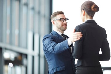 Kendine güvenen çalışan havaalanında konuşma sırasında meslektaşının omzunda elini tutarak