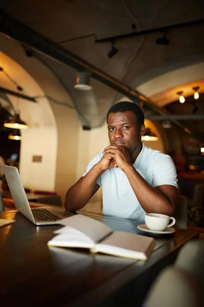 Joven Hombre Afroamericano Serio Sentado Junto Mesa Cafetería Organizando Trabajo — Foto de Stock