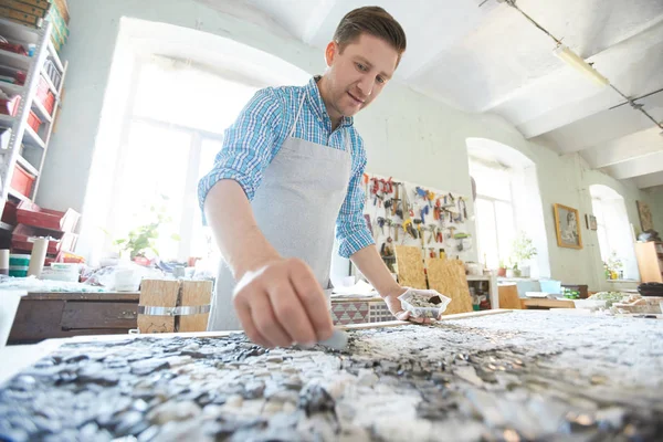 Fiatal Kézműves Kötényben Hajol Fedélzetre Miközben Mozaikképet Fektet Műhelyében — Stock Fotó