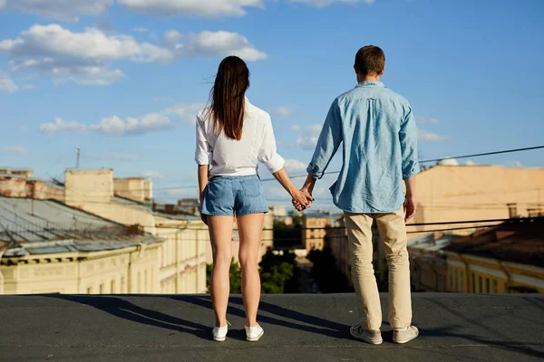 Vista Trasera Joven Pareja Cogida Mano Pie Techo Mientras Mira — Foto de Stock