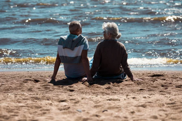 Powrót Widzenia Starszy Para Siedzi Piaszczystej Plaży Rozmawiając Relaksu Przed — Zdjęcie stockowe