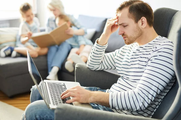 Jovem Com Laptop Sentado Poltrona Navegando Rede Com Sua Família — Fotografia de Stock